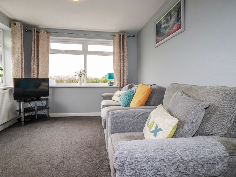 A living room with a television and sofa at Moorland View Belowda near Roche