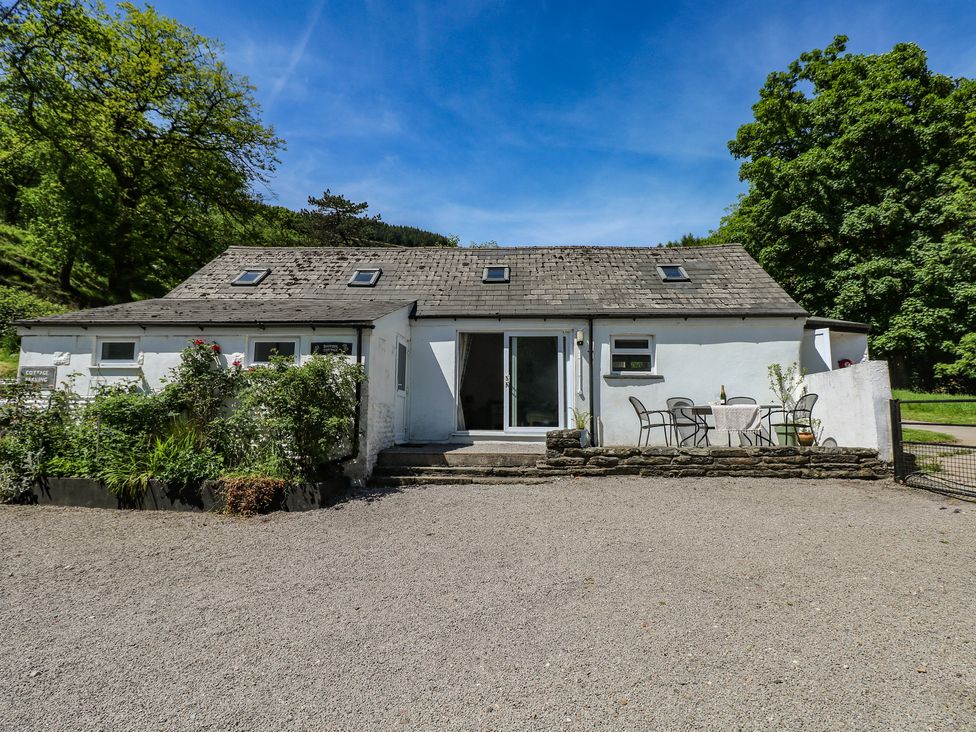A cottage with a table and chairs at Daffodil Cottage in Blaencwm near Treorchy