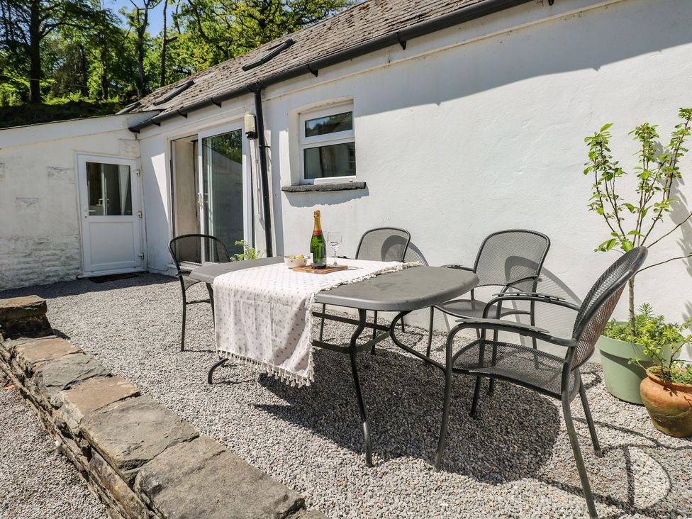 An outdoor dining area with a table and chairs at Daffodil Cottage in Blaencwm near Treorchy