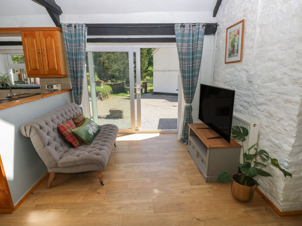 A living room with a sofa and television at Daffodil Cottage in Blaencwm near Treorchy