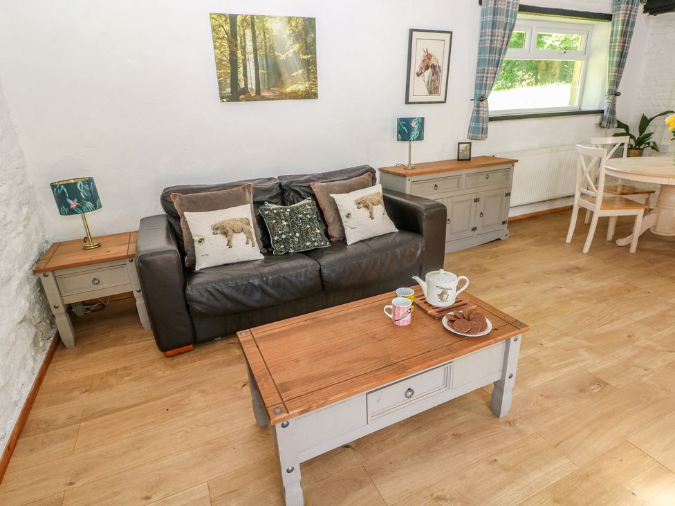 A living room with a sofa and coffee table at Daffodil Cottage in Blaencwm near Treorchy
