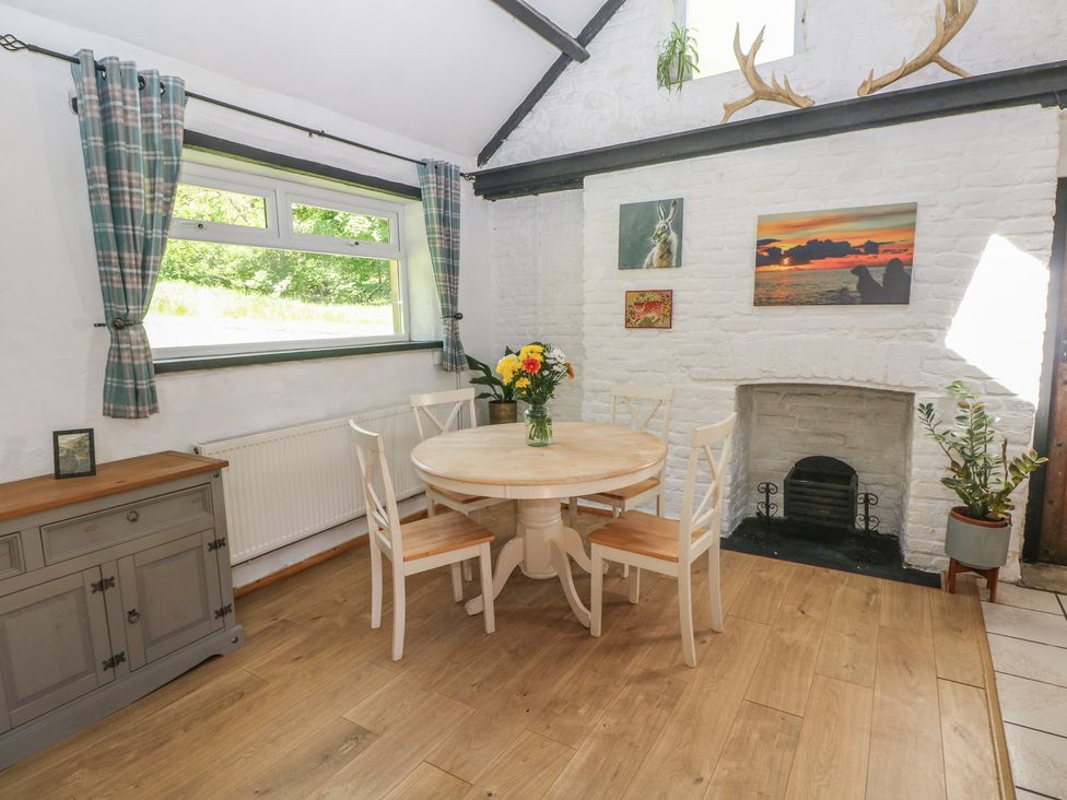 A dining room with a table and chairs at Daffodil Cottage in Blaencwm near Treorchy