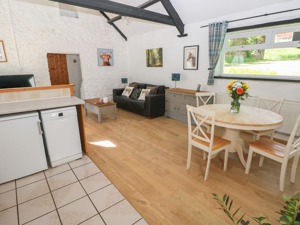A living room with a sofa, table and chairs at Daffodil Cottage in Blaencwm near Treorchy