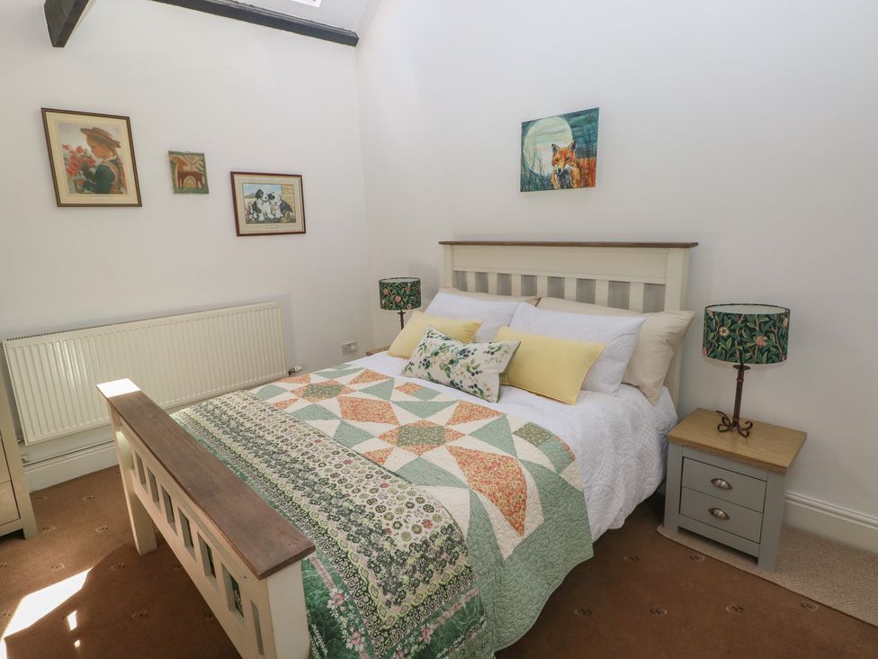 A bedroom with a quilted bed at Daffodil Cottage in Blaencwm near Treorchy