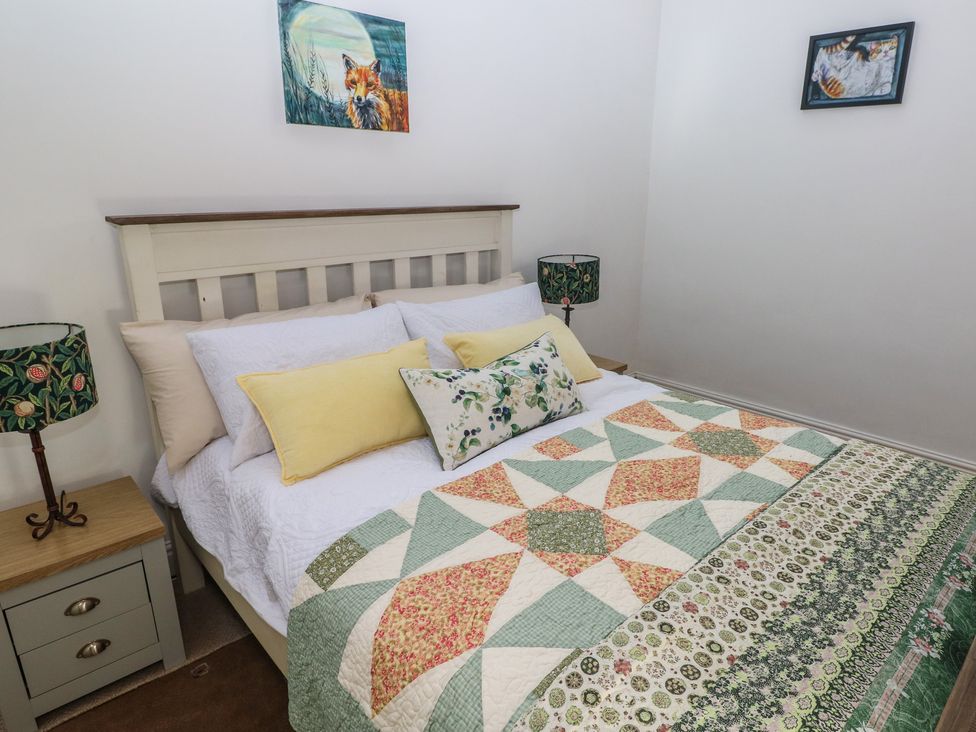 A bedroom with a bed and decorative items at Daffodil Cottage in Blaencwm near Treorchy