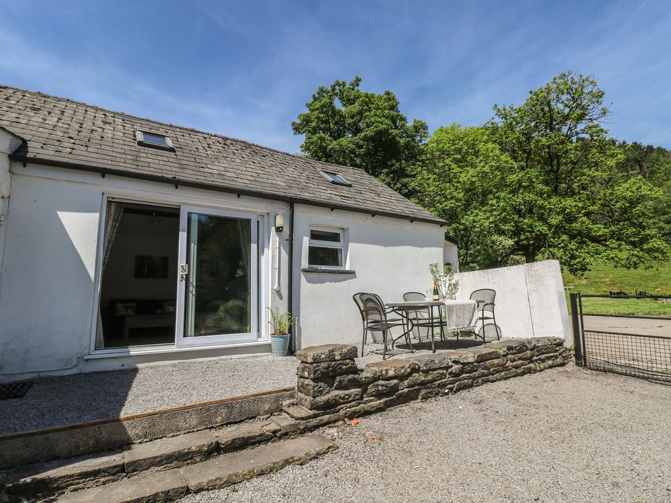 An outdoor seating area with a table and chairs at Daffodil Cottage in Blaencwm near Treorchy