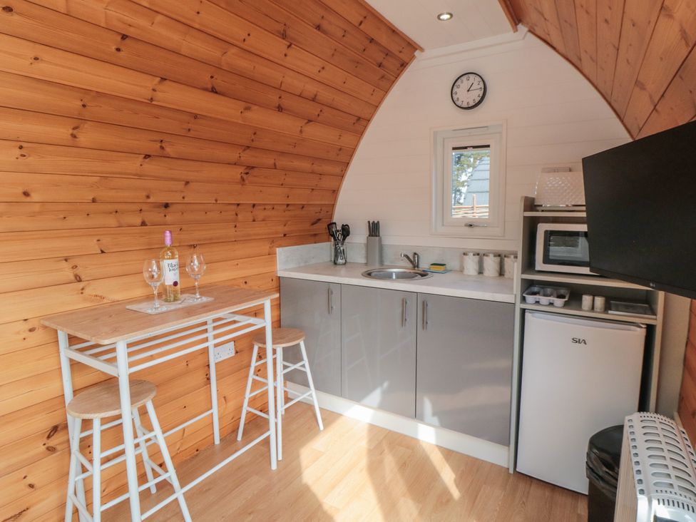 A kitchen with a bar table and a sink at Cosy Cocoon in Malton