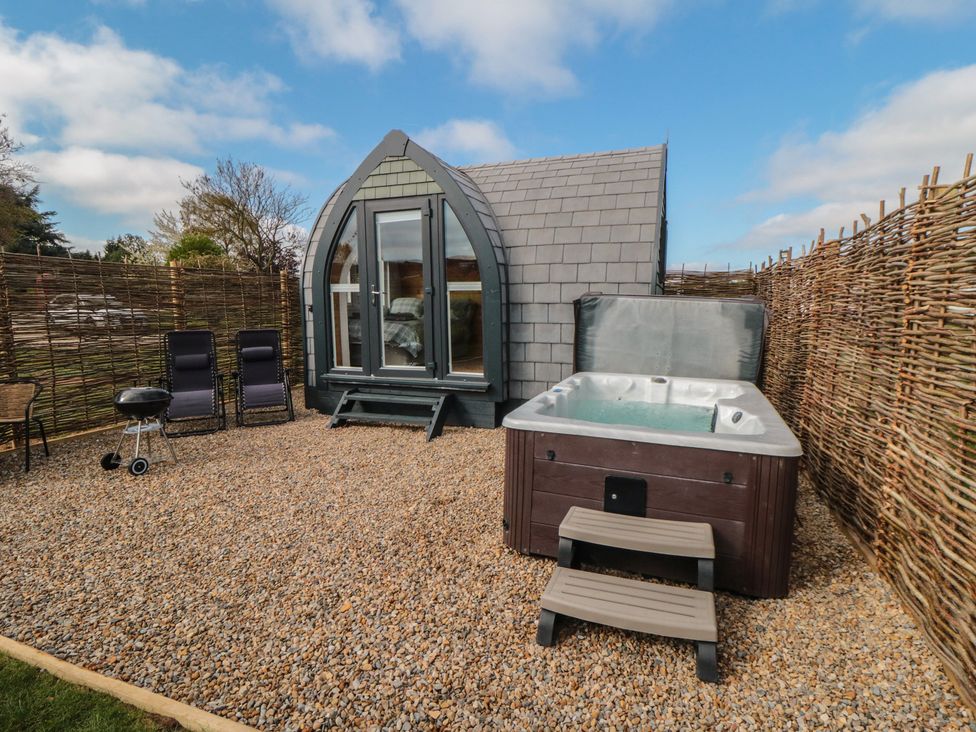 An outdoor area with a hot tub and seating at Cosy Cocoon in Malton