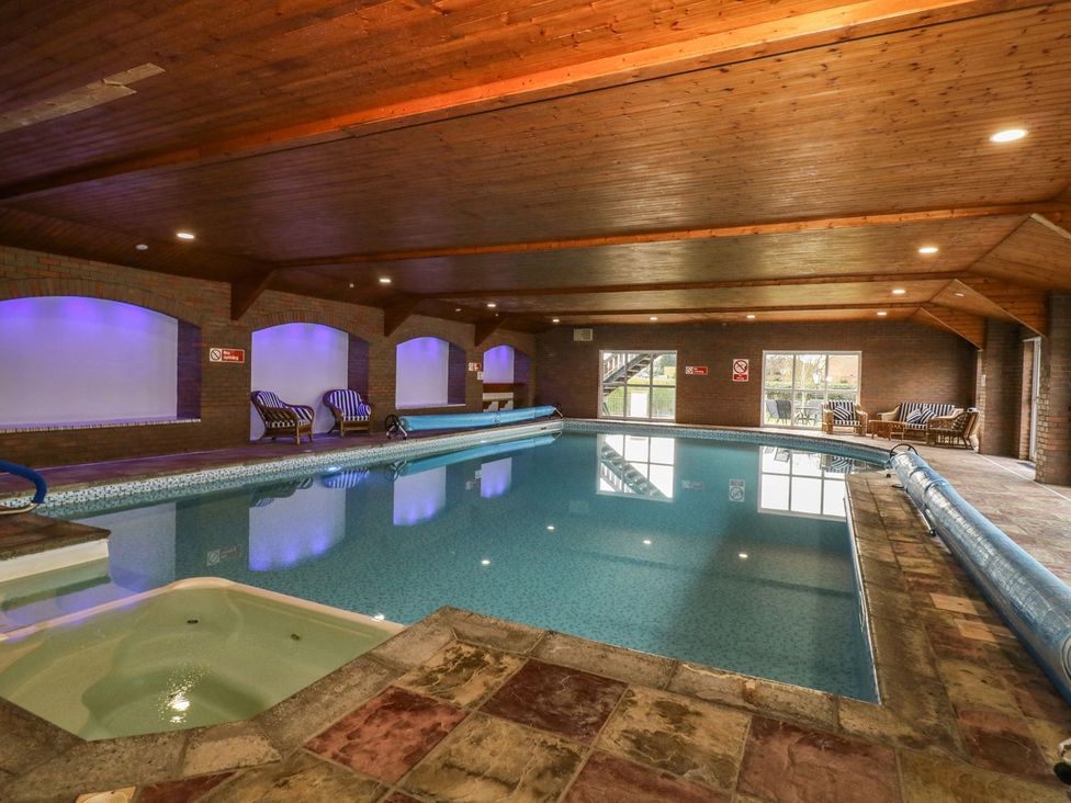 An indoor swimming pool with a hot tub at Natures Nest in Malton