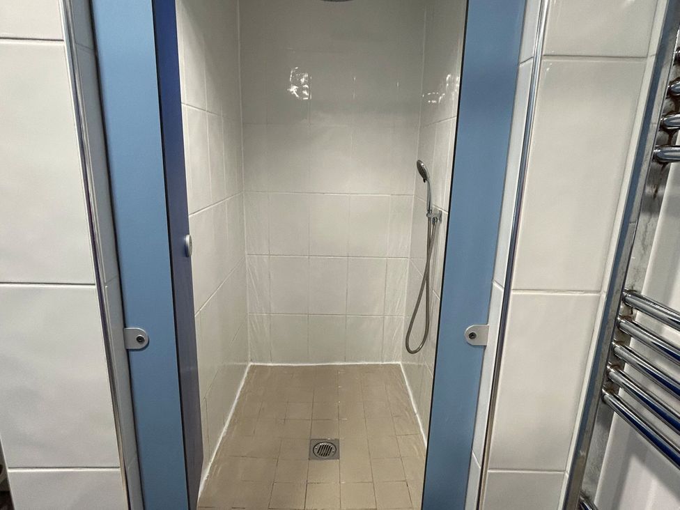 A shower with a showerhead and drain at Natures Nest near Rillington