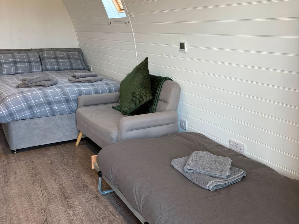 A bedroom with a bed and chair at Natures Nest near Rillington
