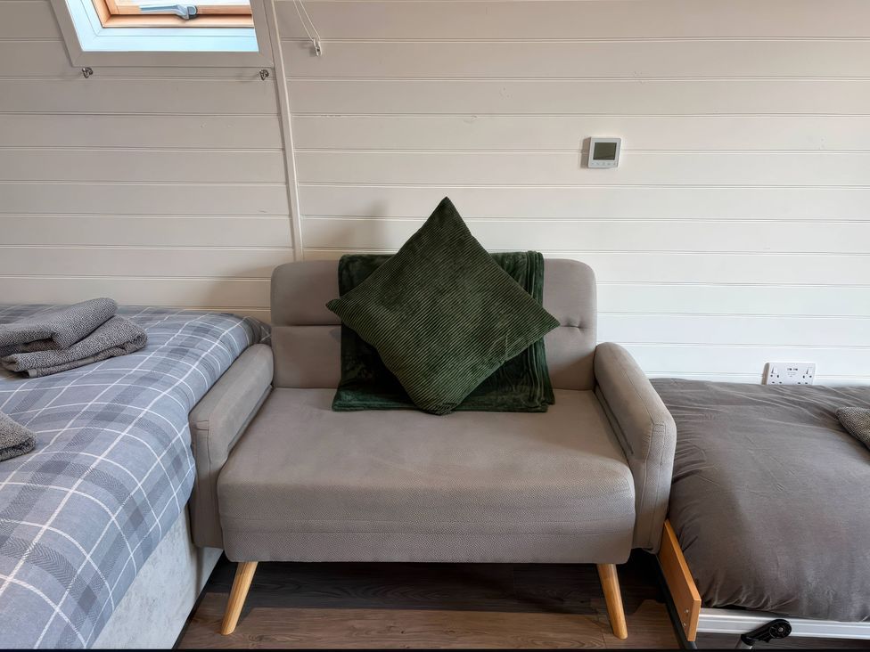 A bedroom with a sofa and bed at Natures Nest near Rillington
