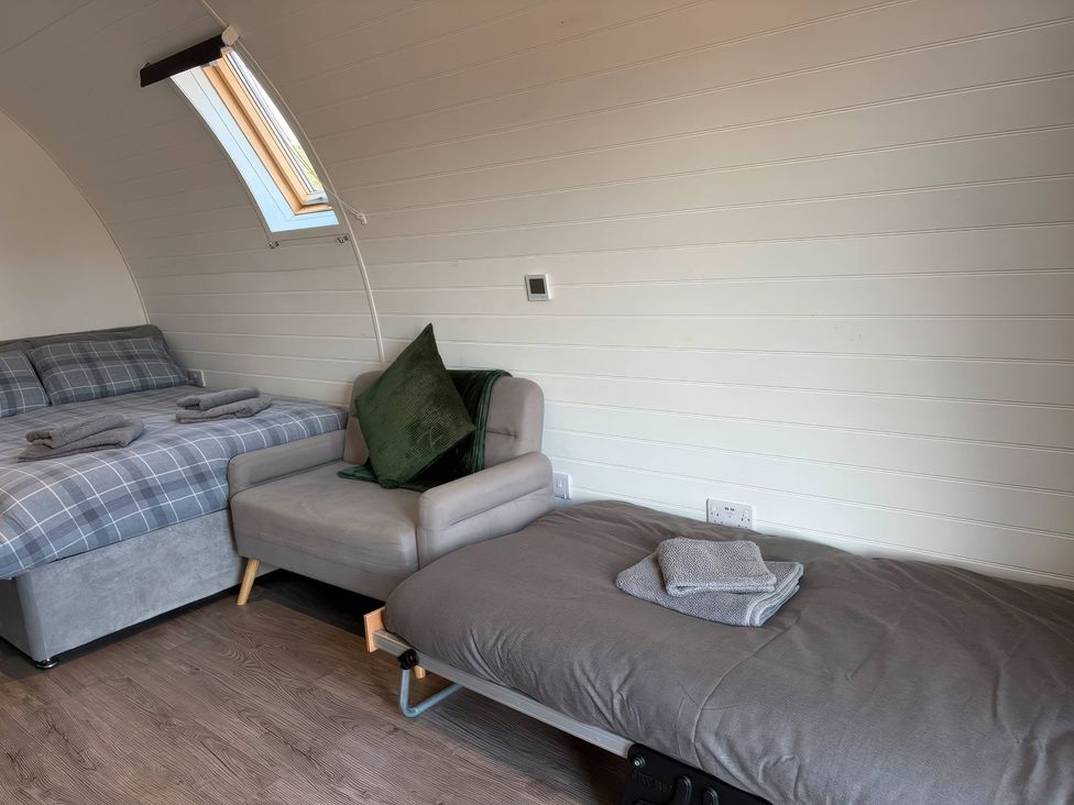 A bedroom with a bed and a sofa at Natures Nest near Rillington