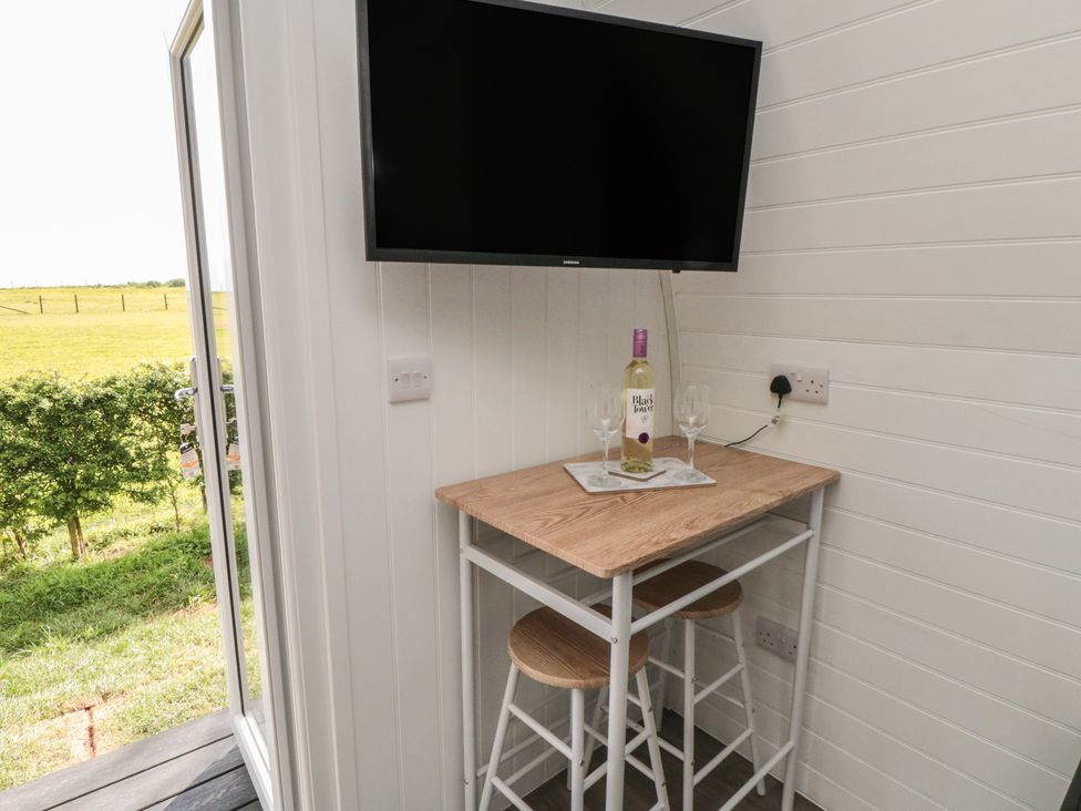 A dining area with a table and TV at Starlight Sanctuary in Malton