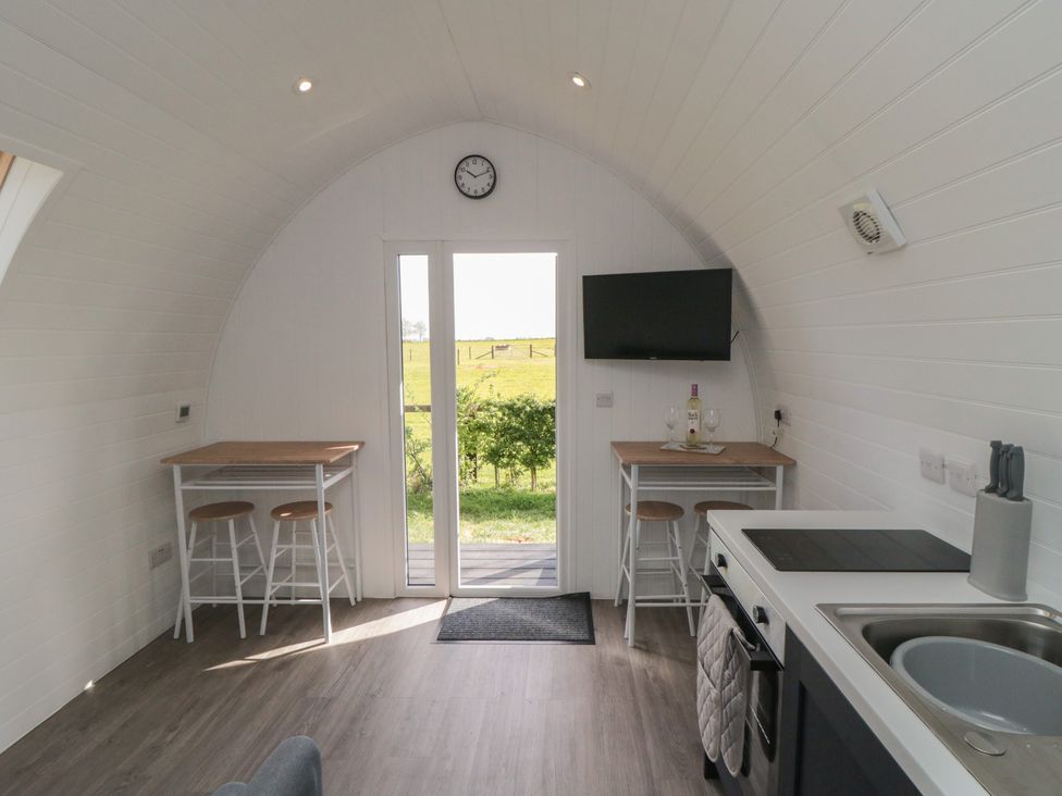 A kitchen with stools and a table at Starlight Sanctuary in Malton