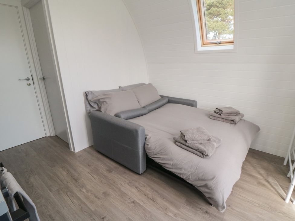 A bedroom with a sofa bed and towels arranged at Starlight Sanctuary in Malton