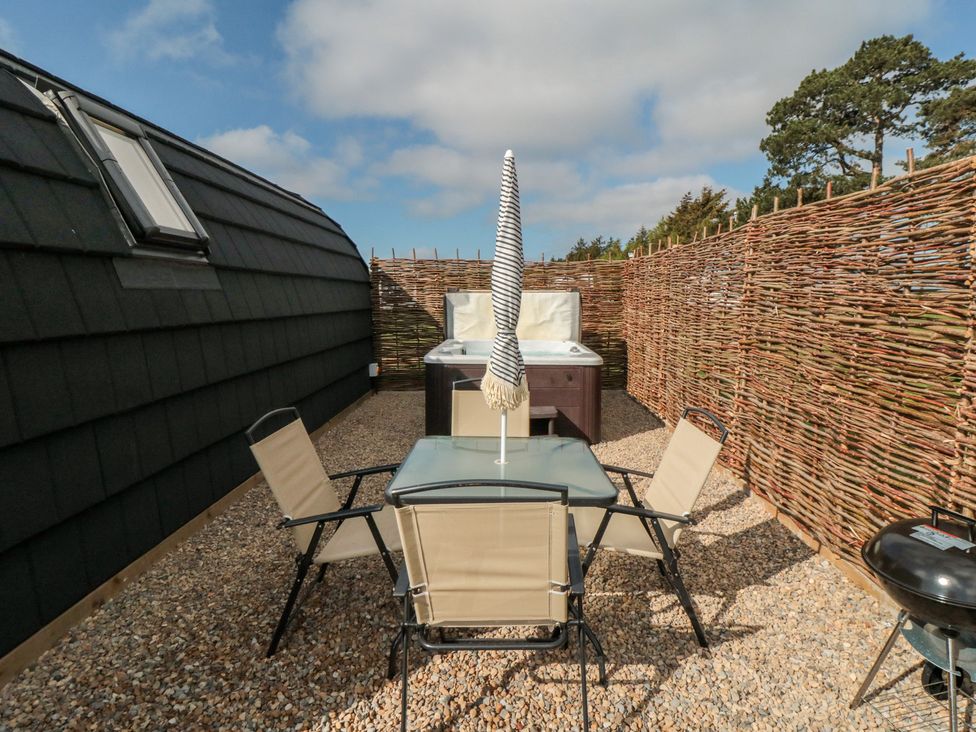 An outdoor area with a hot tub and table with chairs at Starlight Sanctuary in Malton