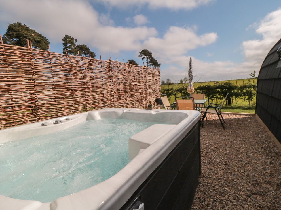 An outdoor area with a hot tub and seating at Starlight Sanctuary in Malton