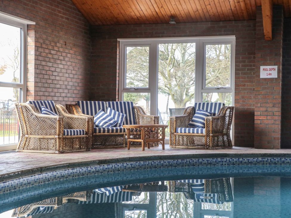 A seating area with a sofa and chairs next to a pool at Starlight Sanctuary in Malton