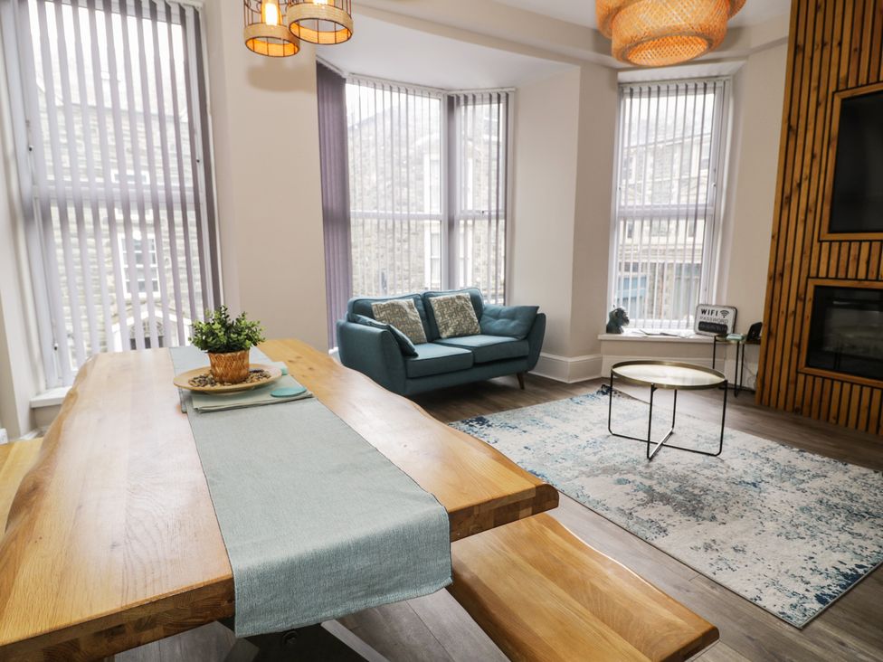 A living room with a dining table, sofa, and coffee table at Llety Cllyd, Barmouth