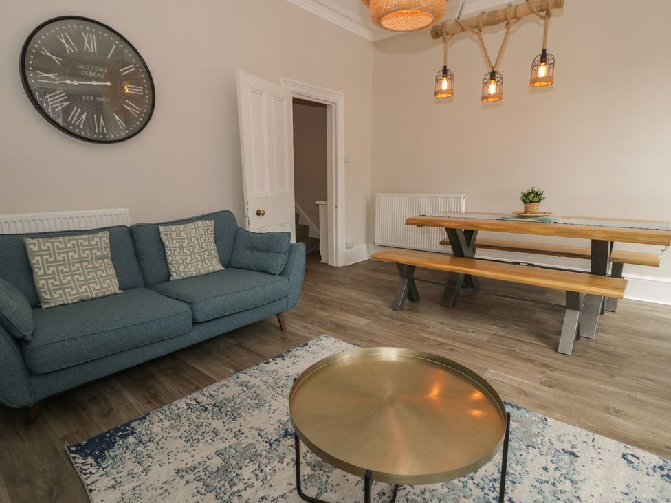 A living room with a sofa and dining area at Llety Cllyd in Barmouth