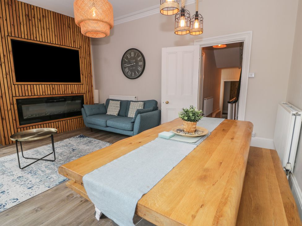 A living room with a sofa and dining table at Llety Cllyd in Barmouth
