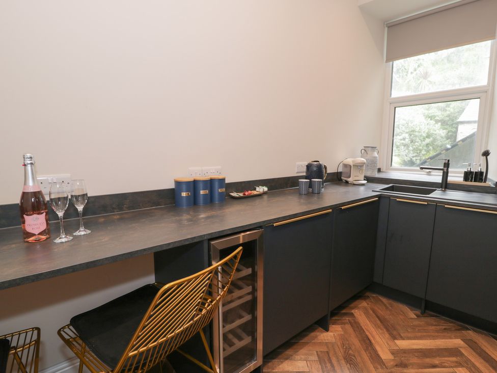 A kitchen with storage cupboards and a sink at Llety Cllyd in Barmouth