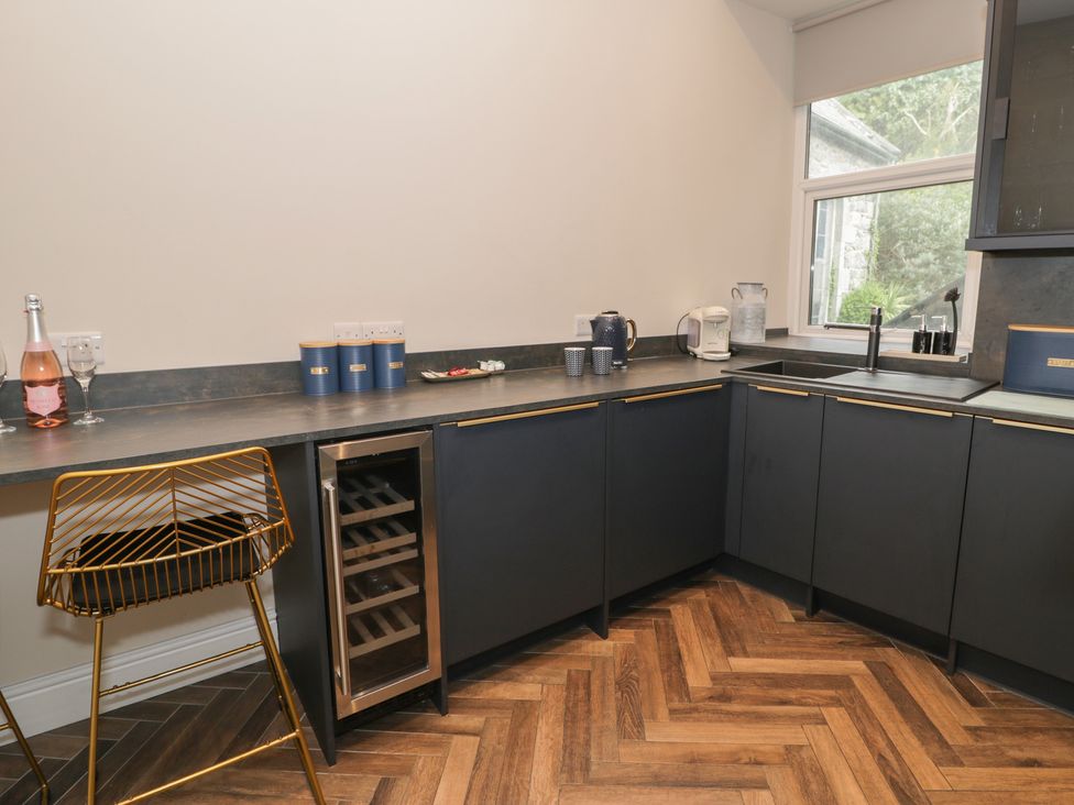 A kitchen with wine glasses and a bottle on the counter at Llety Cllyd Barmouth