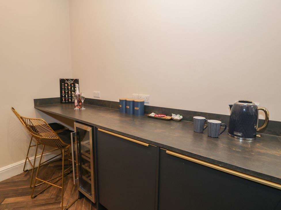 A kitchen with a bar area and beverage items at Llety Cllyd Barmouth