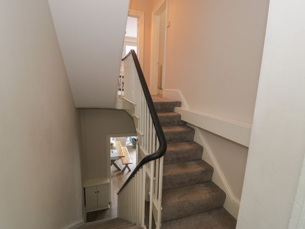 A staircase with a handrail and doorway at Llety Cllyd in Barmouth