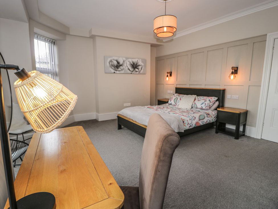A bedroom with a bed, desk, and lamp at Llety Cllyd in Barmouth