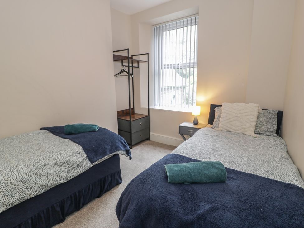 A bedroom with two beds and a nightstand at Llety Cllyd in Barmouth