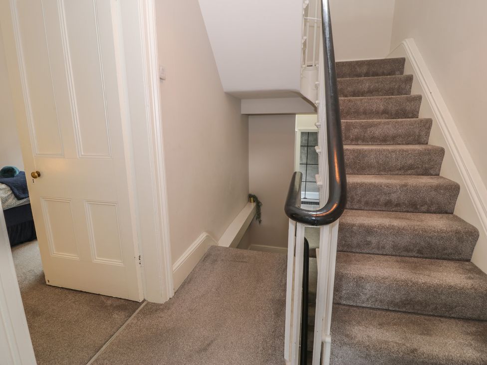 A staircase with carpet and a door at Llety Cllyd Barmouth
