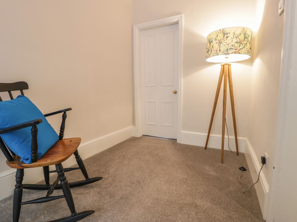 A snug with a rocking chair and floor lamp at Llety Cllyd in Barmouth