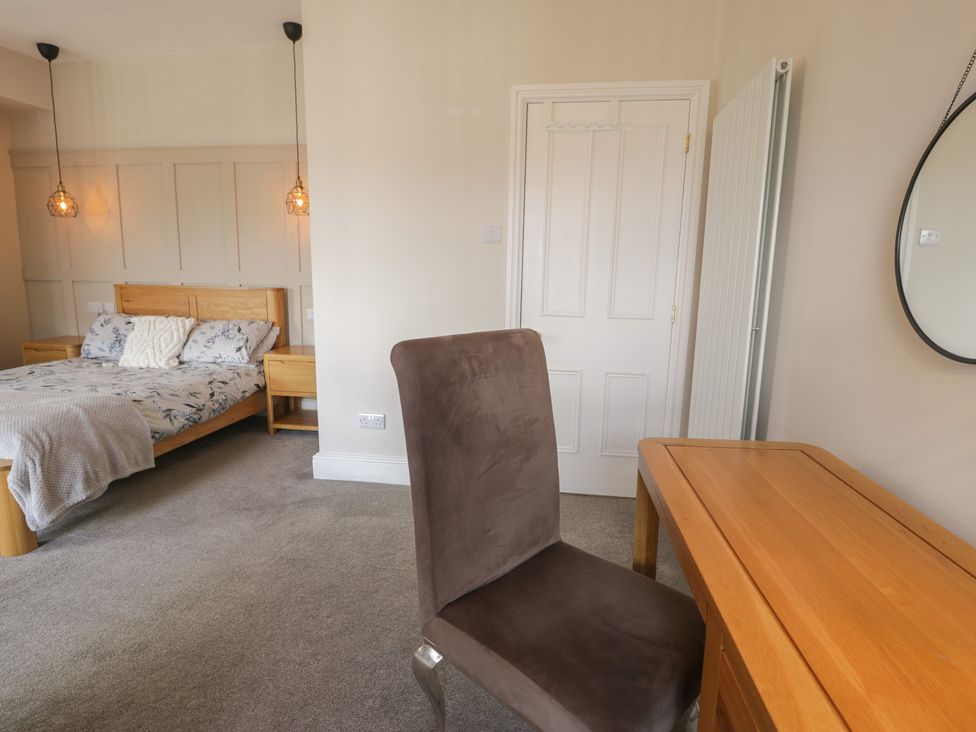 A bedroom featuring a bed, desk, chair, and mirror at Llety Cllyd in Barmouth