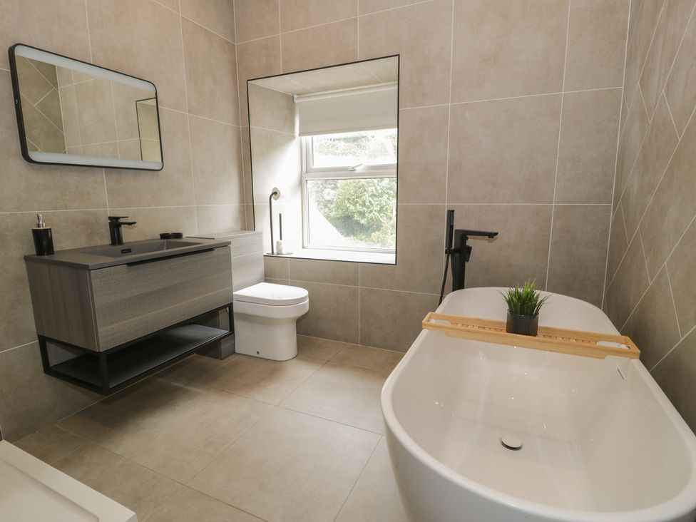 A bathroom with a bathtub, toilet, and vanity at Llety Cllyd in Barmouth