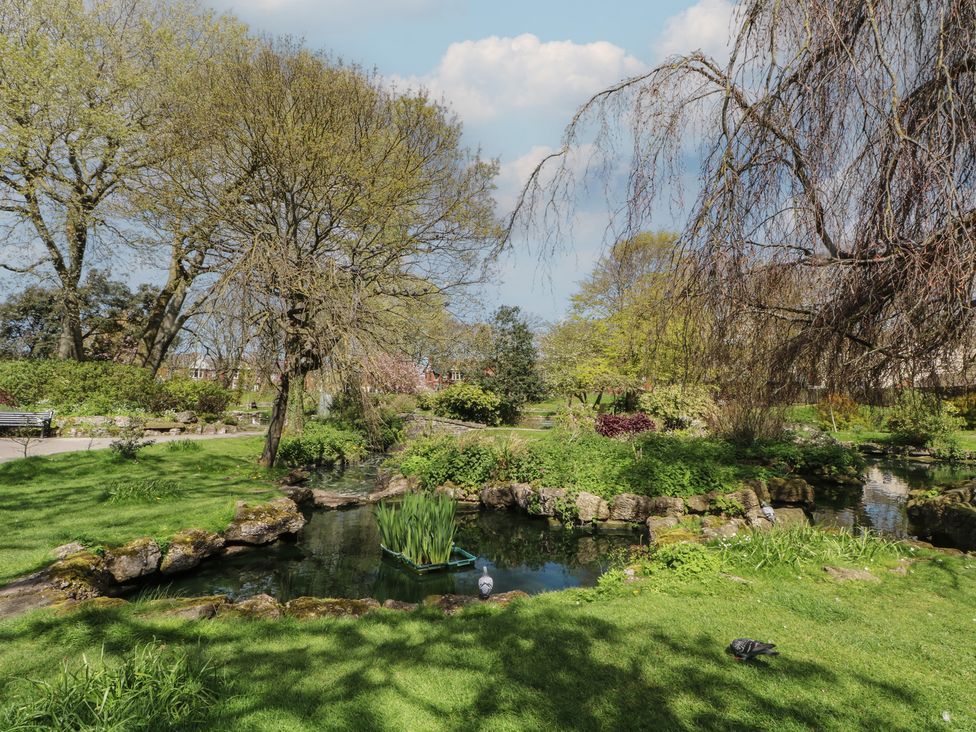 A park with a pond and trees at Apartment 3 in Lytham St. Annes