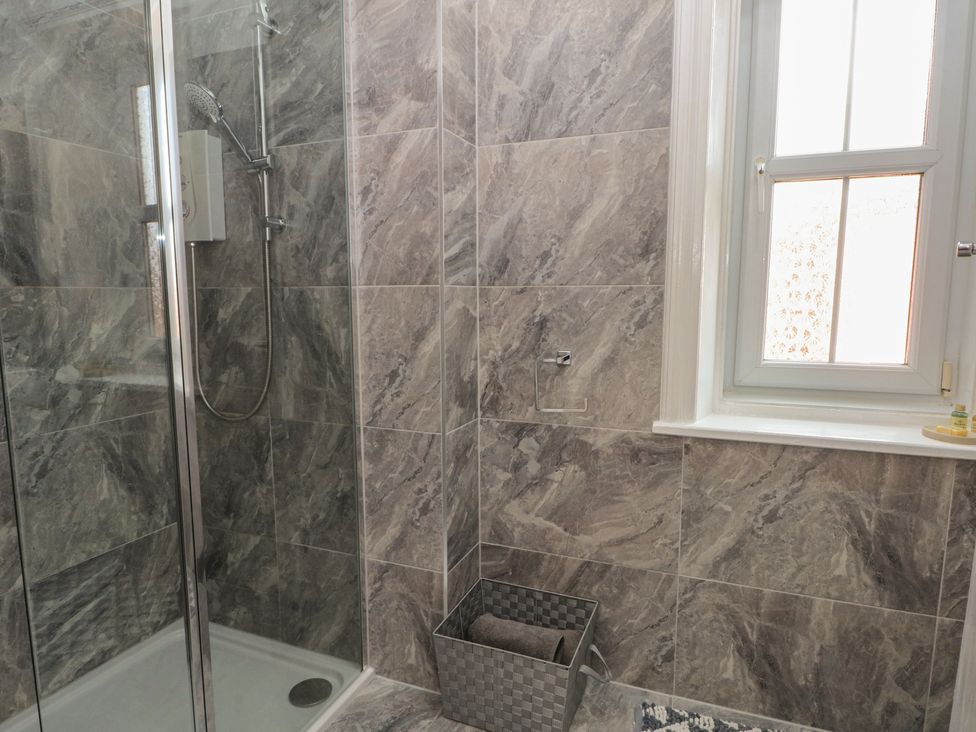 A bathroom with a shower and a towel basket at Apartment 4 in Lytham St. Annes