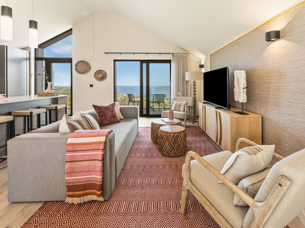 A living room with a sofa and coffee table at Clifftop House Hot Tub St Ives