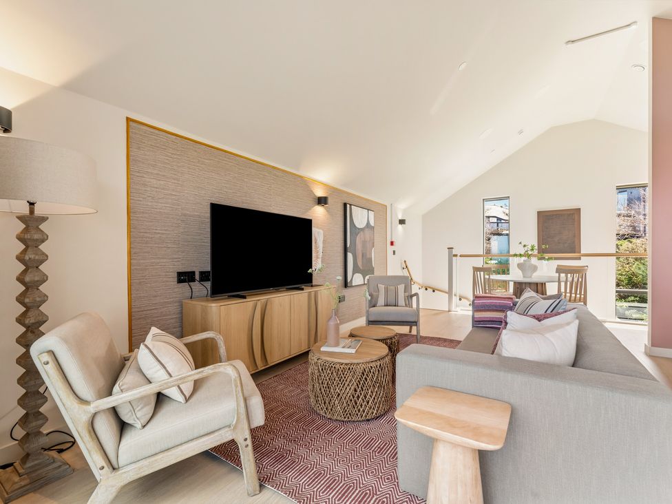 A living room with a television, sofa and armchair at Clifftop House Hot Tub, St Ives