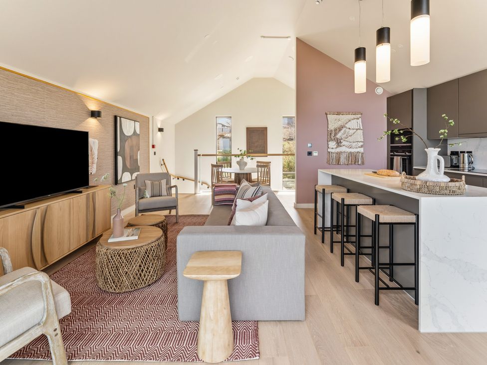 A living room with a television, sofa, and dining area at Clifftop House Hot Tub in St Ives