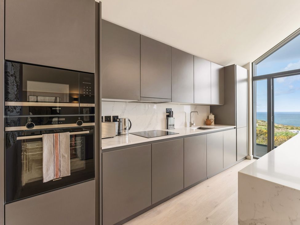 A kitchen with cabinets and appliances at Clifftop House Hot Tub St Ives