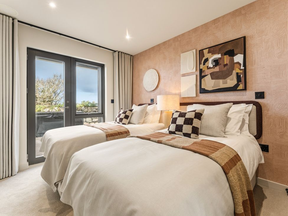 A bedroom with two beds and artwork at Clifftop House Hot Tub St Ives