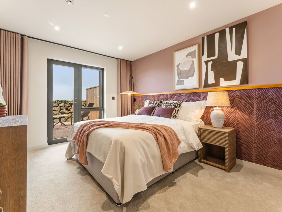 A bedroom with a bed and side table at Clifftop House Hot Tub in St Ives