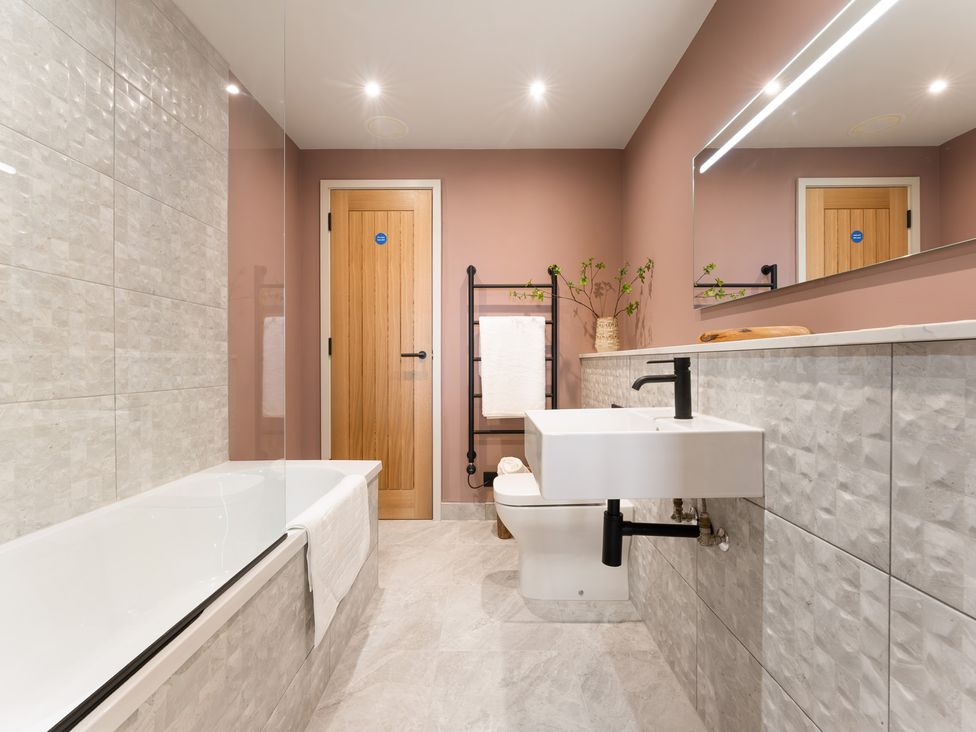A bathroom with a bathtub, sink, and toilet at Clifftop House Hot Tub, St Ives
