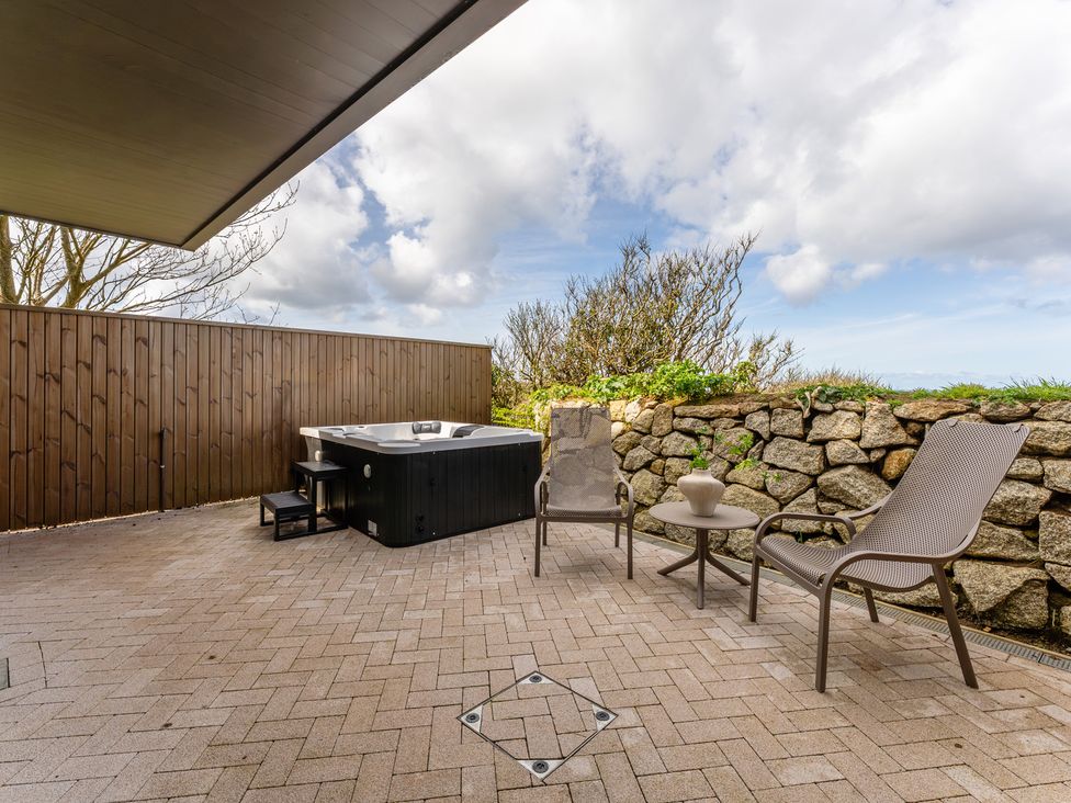 An outdoor area with a hot tub and seating at Clifftop House Hot Tub in St Ives