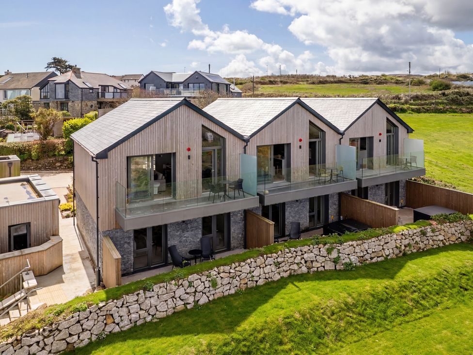 A modern building with balconies and a stone wall at tbc in St. Ives