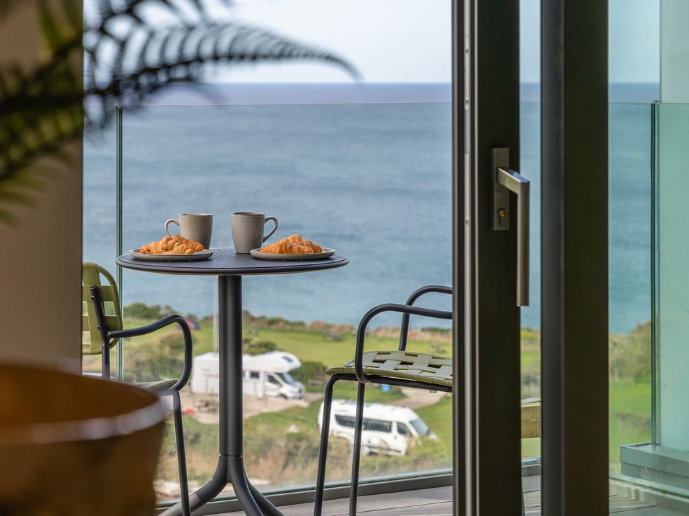 A table with mugs and croissants on a balcony with a sea view at tbc in St. Ives