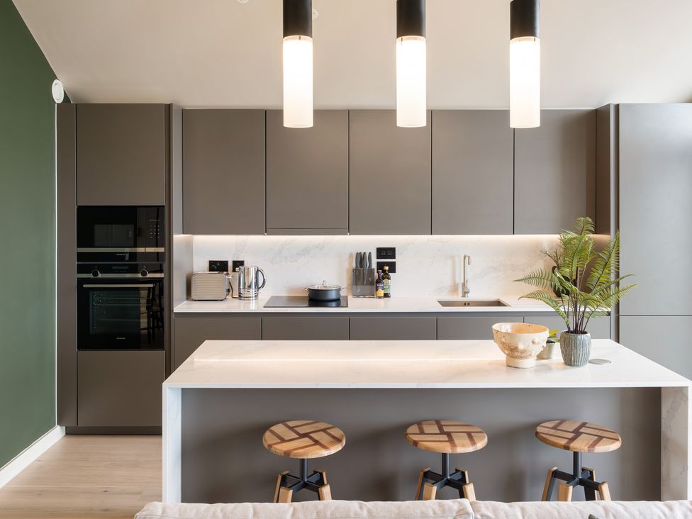 A kitchen with a bar counter and stools at tbc in St. Ives