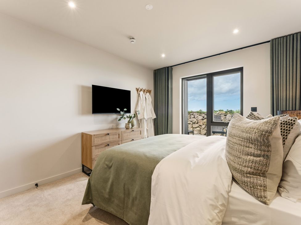 A bedroom with a bed, dresser and TV at tbc in St. Ives